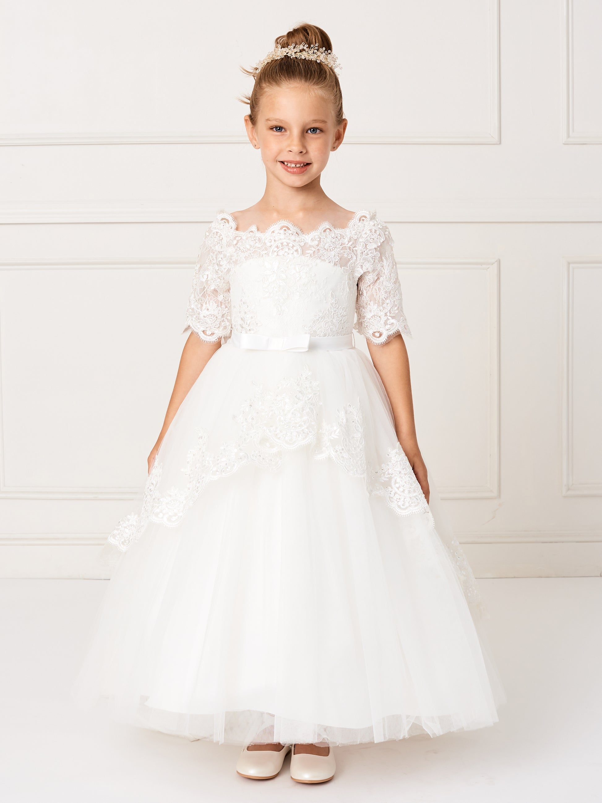 This gorgeous off shoulder dress is perfect for your little girl. The center of the dress has a simple bow at the waist.This dress features a lace peplum skirt with a long train on the back that has beautiful embroidered details. Skirt has additional netting crinoline underneath that can be puffed up if extra fullness is desired. Fully lined, zipper back, and satin sash tie-back.  Available Size: 4  Available Color: Ivory