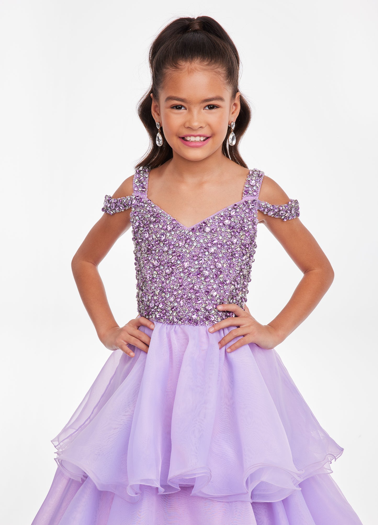 Ashley Lauren Kids 8101 Girls Pageant Dress.  The crystal encrusted bodice on this kids Pageant Gown consists of a slight V-Neckline and off the shoulder straps. The A Line multi-tiered organza ruffle skirt completes the look with a long train.   Available colors:  Hot Pink, Lilac, Turquoise