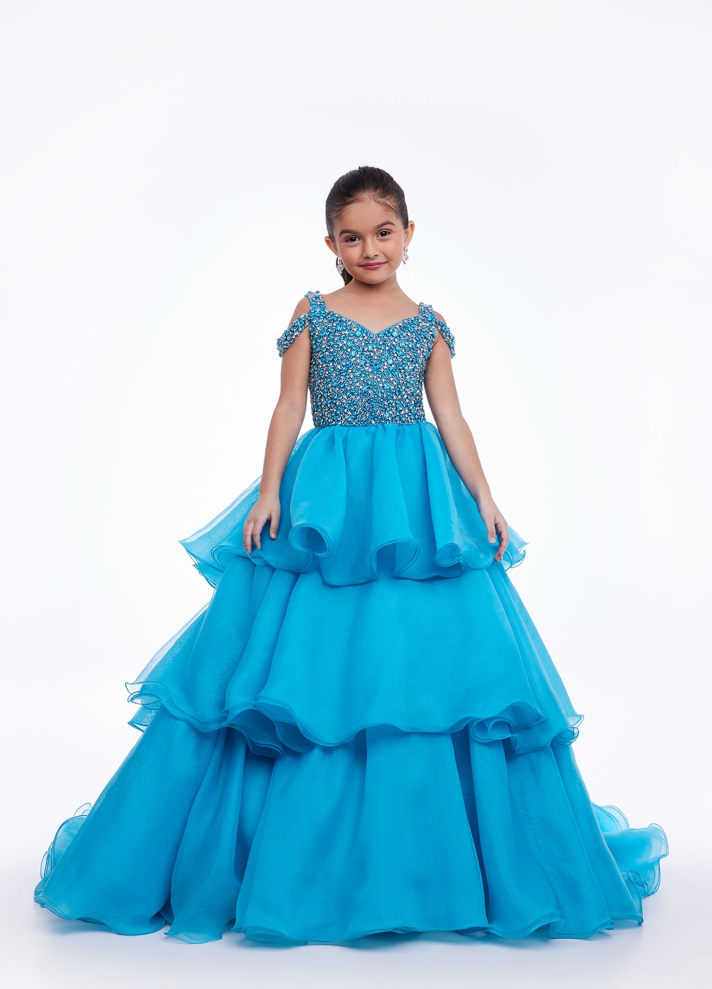 Ashley Lauren Kids 8101 Girls Pageant Dress.  The crystal encrusted bodice on this kids Pageant Gown consists of a slight V-Neckline and off the shoulder straps. The A Line multi-tiered organza ruffle skirt completes the look with a long train.   Available colors:  Hot Pink, Lilac, Turquoise