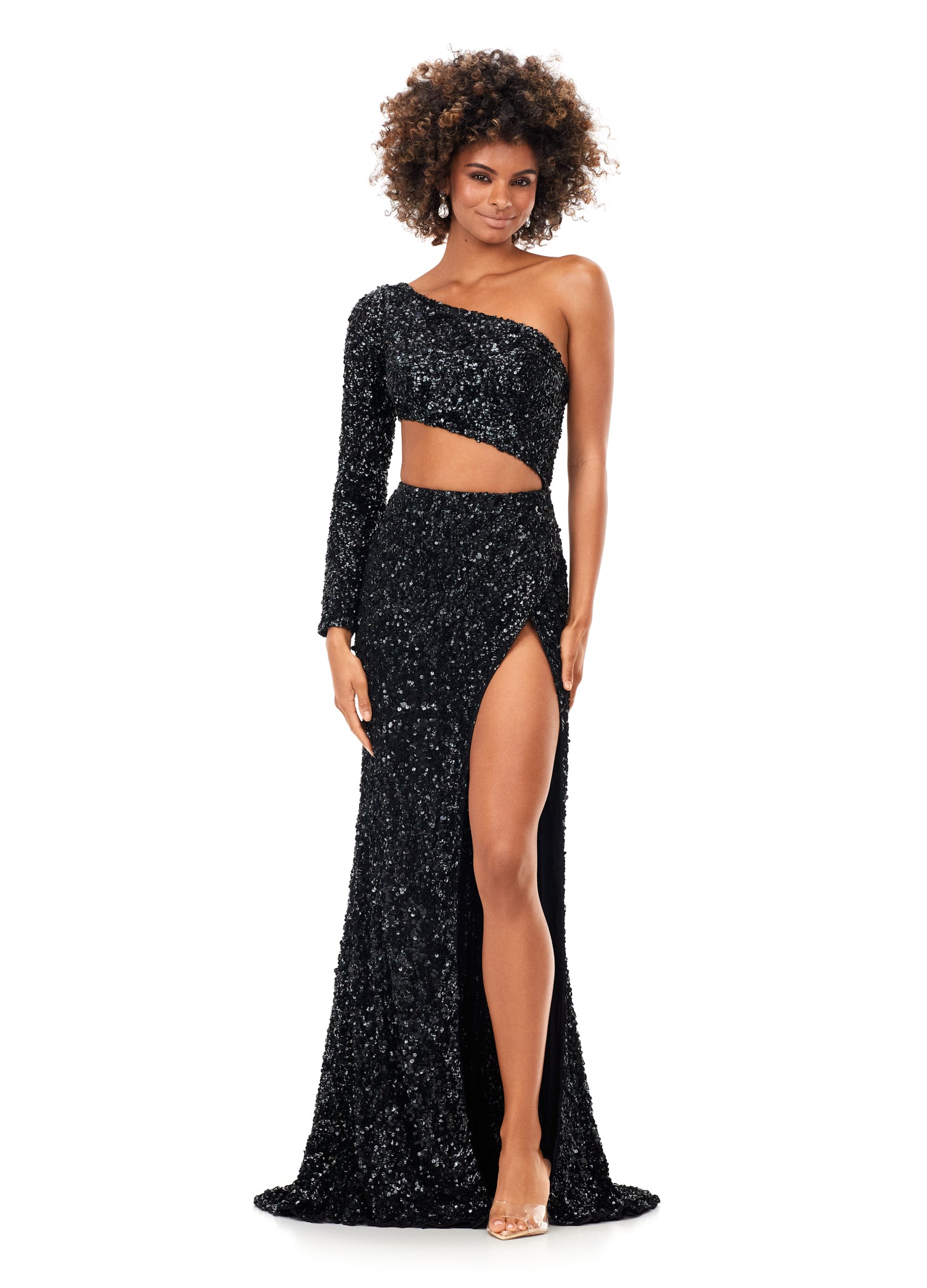 Ashley Lauren 11340 This sequin one shoulder gown features one sleeve and a shark bite cut out. The gown is complete with a left leg slit.