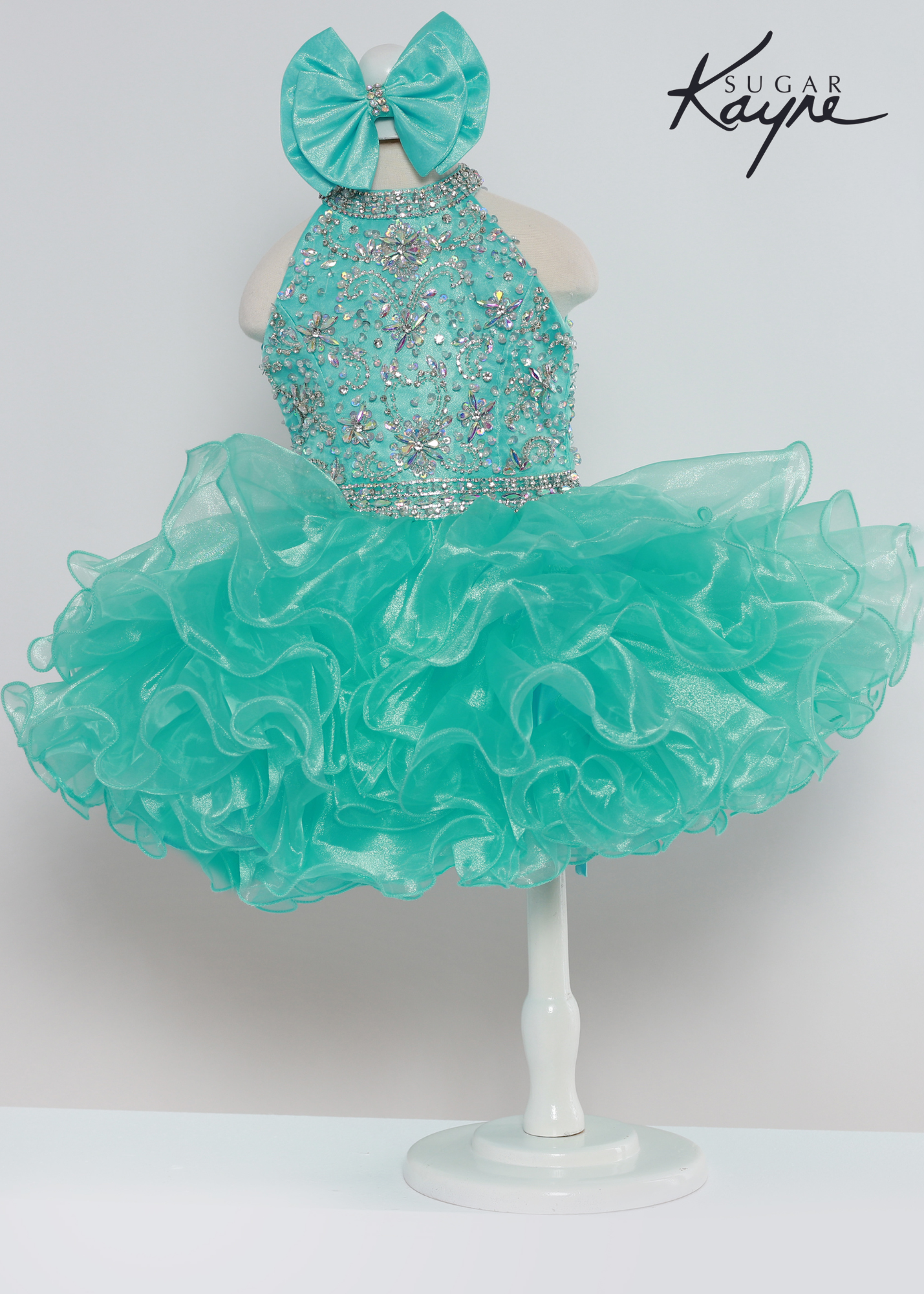 Sugar Kayne C223 Girls Baby Short ruffle Cupcake Pageant Dress Bow Halter Beaded Gown Have your little cupcake bring on all the charm in this stunning organza gown. The corset back is the perfect addition as the little one grows!  Colors: Aqua, Petal Pink, Yellow  Sizes: 0M, 12M, 18M, 24M, 2T, 3T, 4T, 5T, 6M, 6T  Fabric Organza, Satin Lining