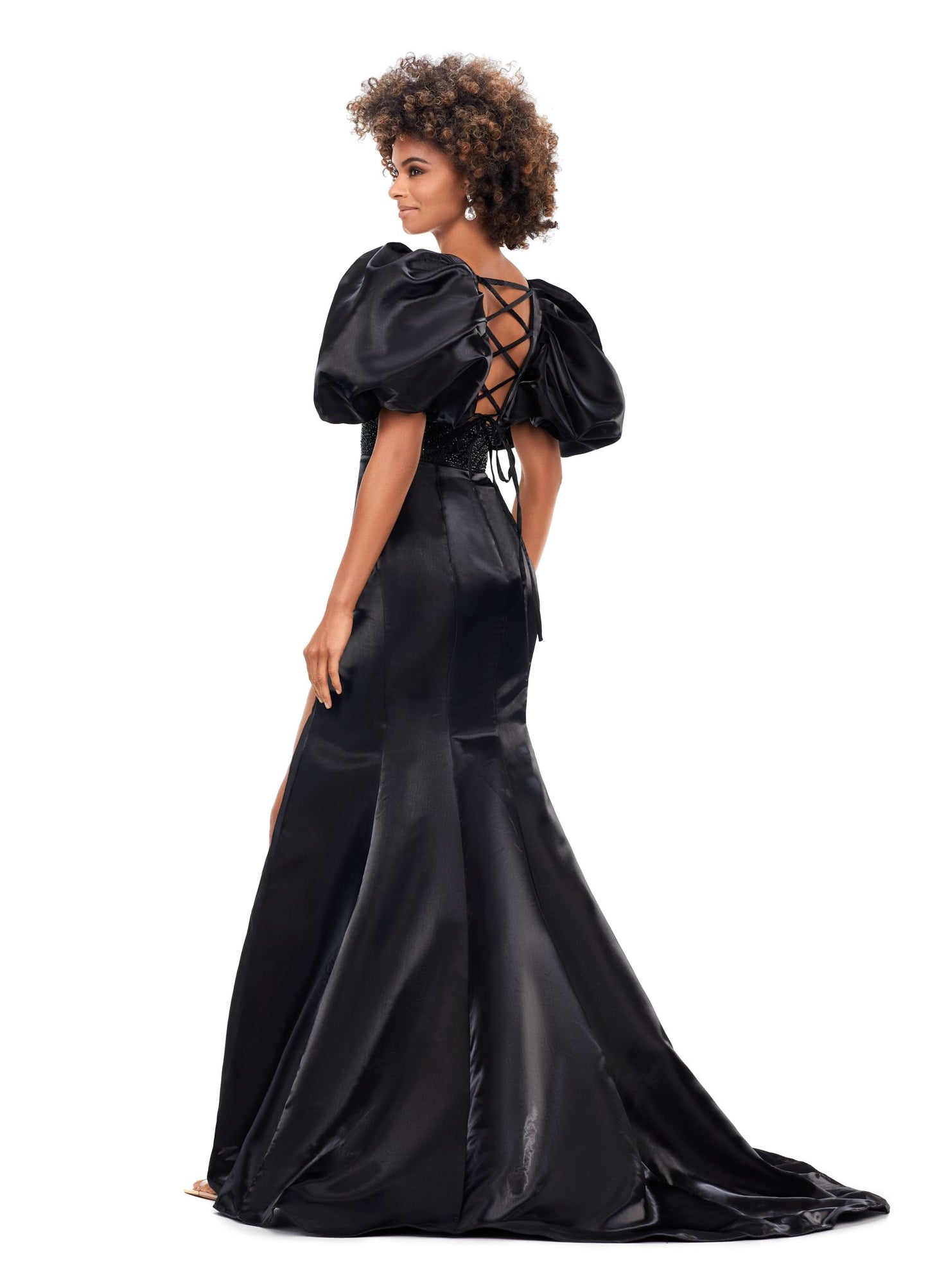 Ashley Lauren 11379 Shine in this v-neckline dress that features oversized puff sleeves. The waistband is embellished with scattered heat set stones and is complete with a lace-up back. V-Neckline Oversized Puff Sleeves Fitted Skirt Shimmer Satin COLORS: Aqua, Black, Red