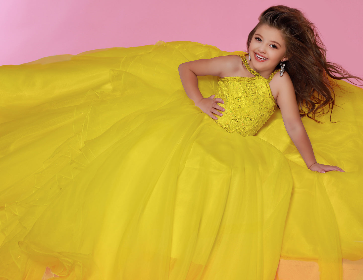 Sugar Kayne C143 Girls and Preteens Pageant Dress.  This is a beautiful flowy organza pageant gown with embellished high neckline.  This dress features an organza ruffle that flows down the back of the dress yellow