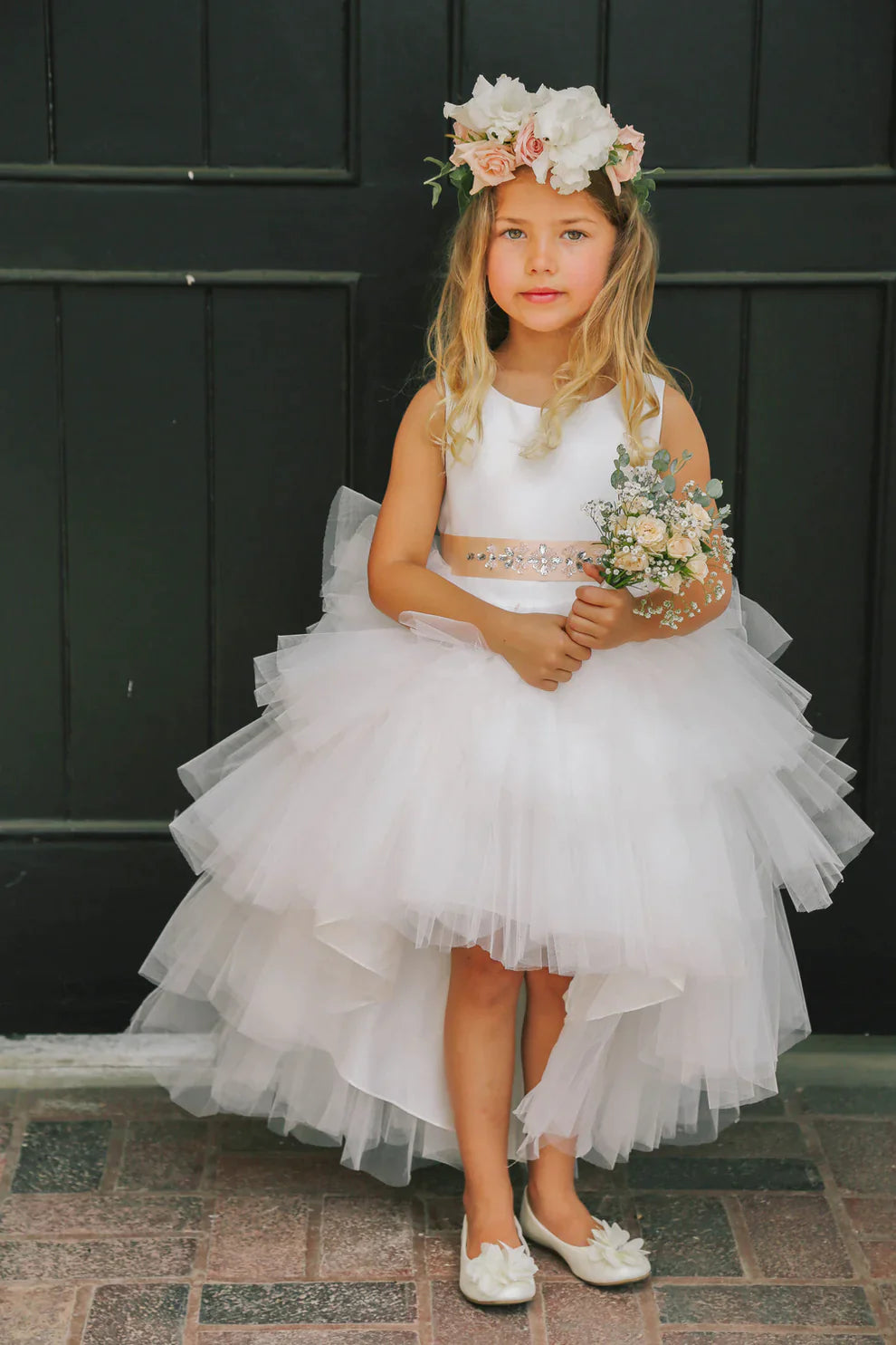 This Tip Top 5658 Girls Layered Tulle High Low Skirt Formal Dress is a perfect choice for that special day. The tulle high-low skirt, satin formal gown, and flower girl satin sash come together to create a beautiful, unique look perfect for flower girls, junior bridesmaids or formal occasions.  Sizes: 6M-16  Colors: Black, Blush, Burgundy, Eggplant, Ivory, Red, Royal Blue, White, Champagne, Lilac, Sky Blue