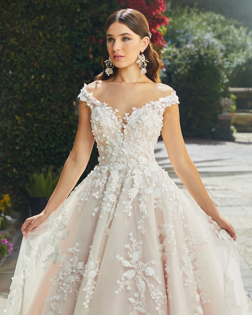 Casablanca Bridal 2406 EVELINA Off the shoulder wedding dress ballgown Bridal Gown. Modern-feminine-chic never looked better than Style 2406 Evelina by Casablanca Bridal. Bold and soft all at once, this classic ballgown wedding dress features a breathtaking sweetheart neckline and off-shoulder sleeves, delicately covered in blooming 3D floral lace. An illusion keyhole back opens up to frame a dreamy row of buttons,