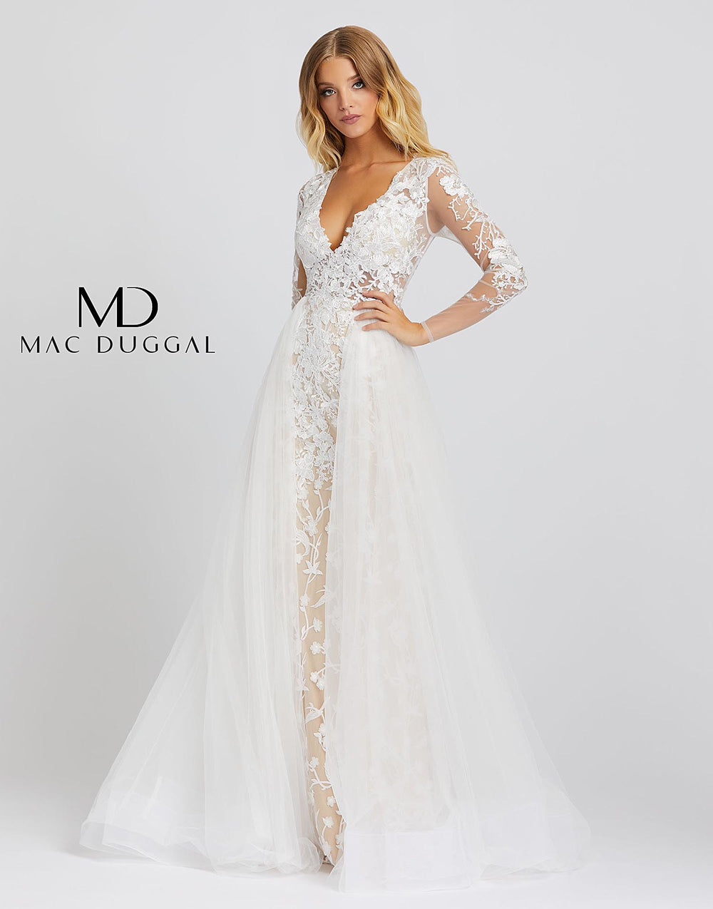 Mac Duggal 26322M - 26322 Love this dress so much you’ll want to re-wear it for your wedding! Style 26322M is an ivory nude ball gown with sheer long sleeves, a v-neckline, and overskirt. This incredible gown has embroidery detailing from head to toe. This Mac Duggal Prom Collection 26322M ivory nude formal gown has a fitted silhouette in embroidered tulle, with a deep V-neckline and illusion long sleeves. The illusion bodice is offset with a fully lined skirt, finished with a gathered overskirt that cascad