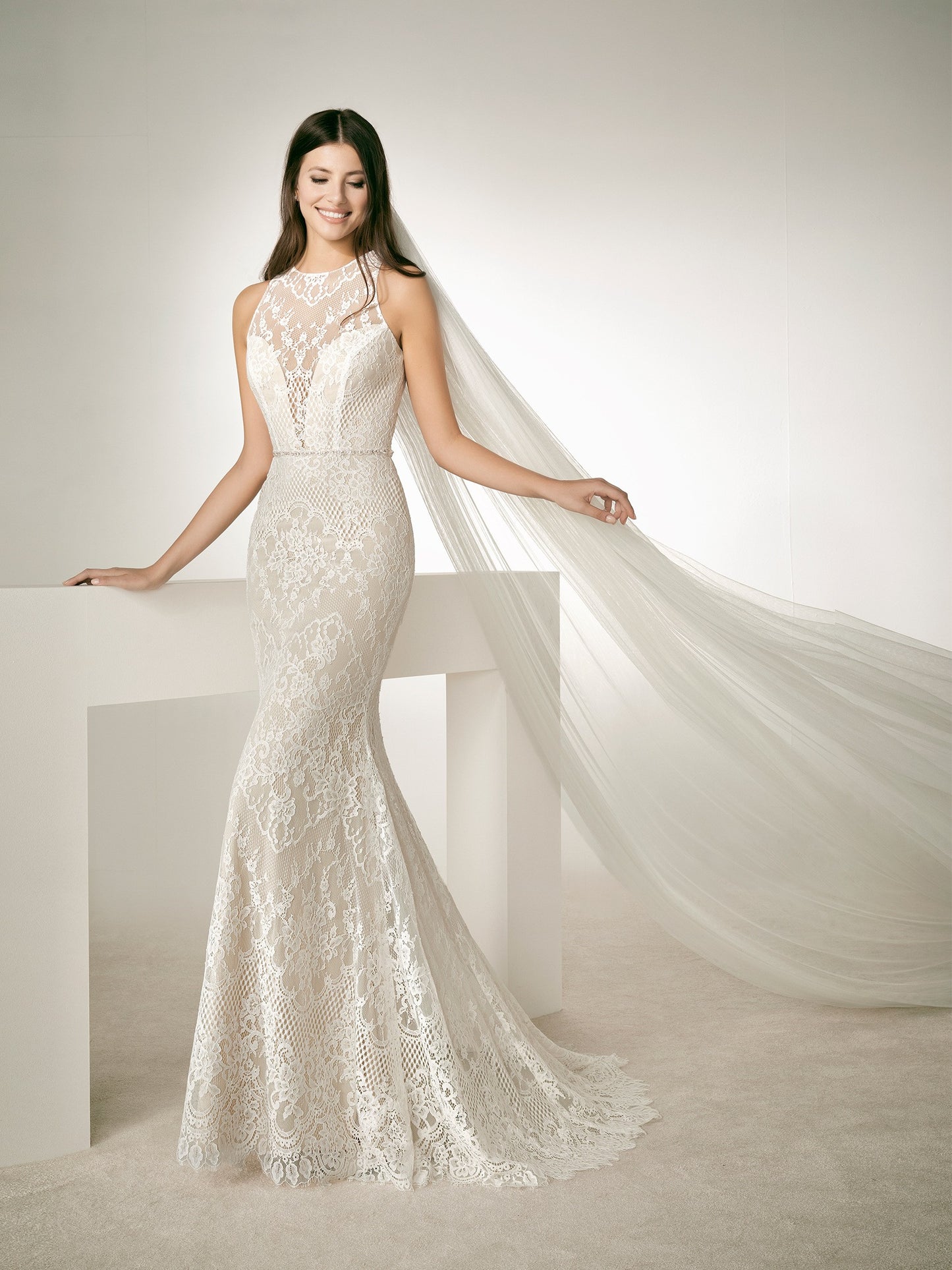 White One Bridal RAF is a stunning Lace Wedding Gown Featuring a Long Fitted Mermaid Silhouette with a Sheer Lace illusion high halter neckline. This sheer Back bridal gown features a crystal waist belt. and sweeping train.  IN STOCK FOR IMMEDIATE DELIVERY   US SIZE 8 -OFF WHITE/LIGHT BEIGE