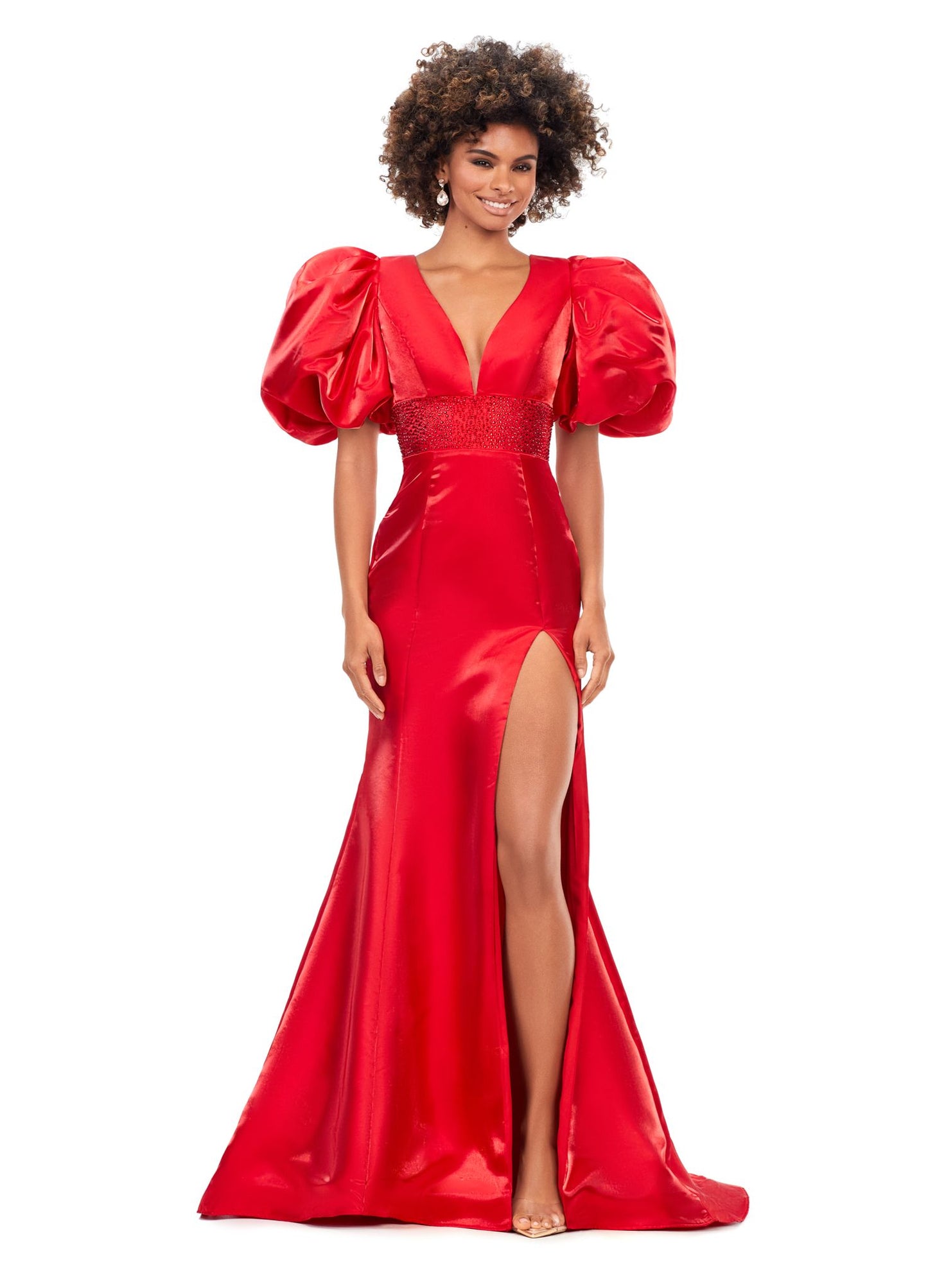 Ashley Lauren 11379 Shine in this v-neckline dress that features oversized puff sleeves. The waistband is embellished with scattered heat set stones and is complete with a lace-up back. V-Neckline Oversized Puff Sleeves Fitted Skirt Shimmer Satin COLORS: Aqua, Black, Red